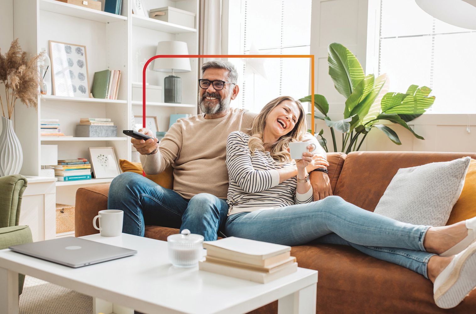 Couple sitting and smiling on couch.