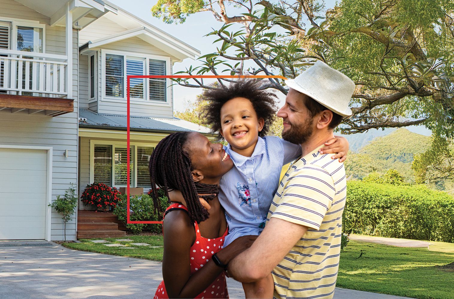 Couple holding child outdoors in front of house