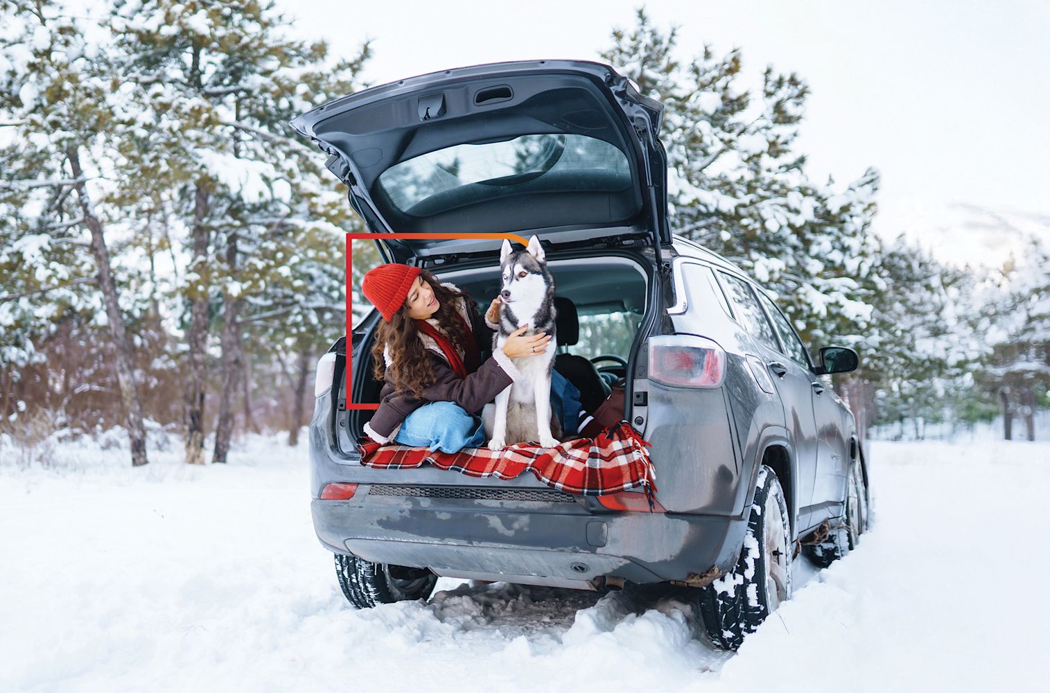 Woman with dog in car out in the snow.