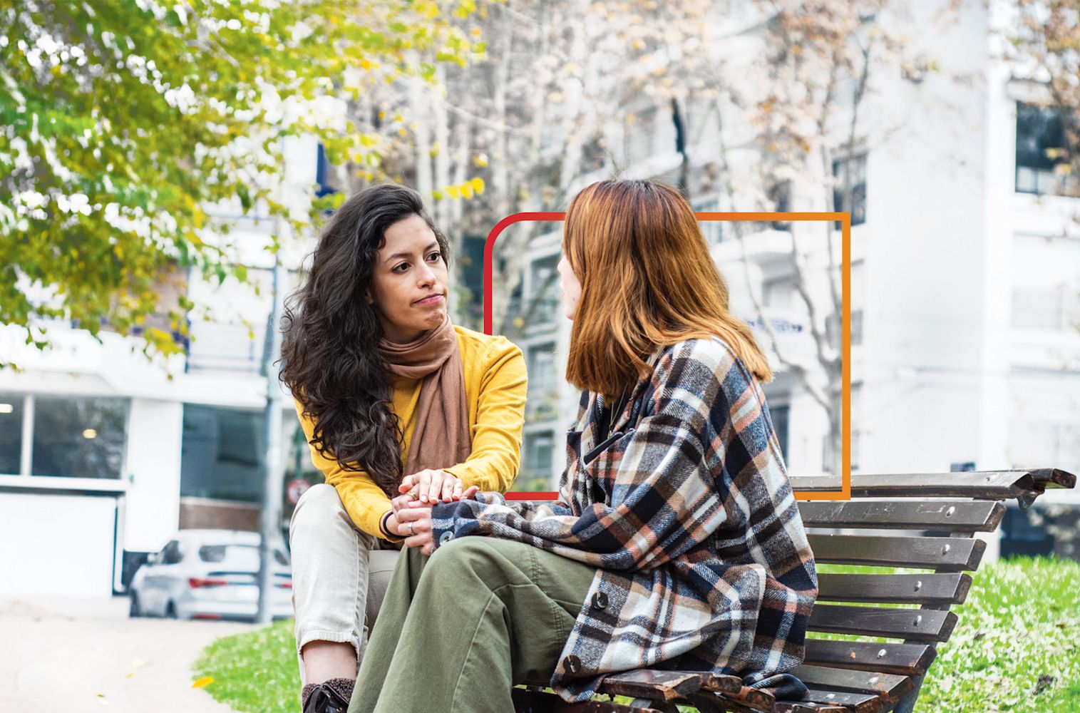 Two women sitting outside on a bench