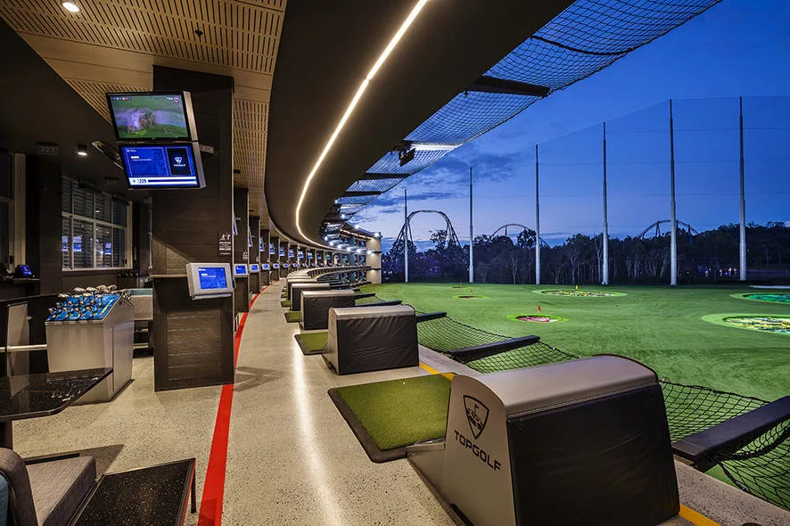 The Topgolf venue, featuring a large screen for interactive gameplay and photo opportunities.