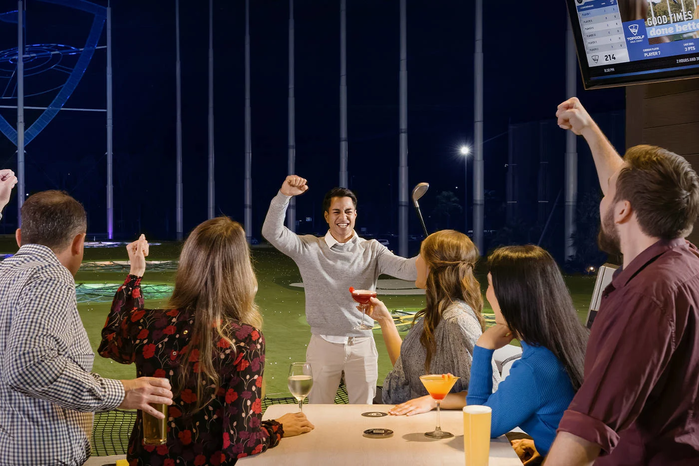 A group of people celebrating at a Topgolf venue, capturing fun moments for memorable photos.