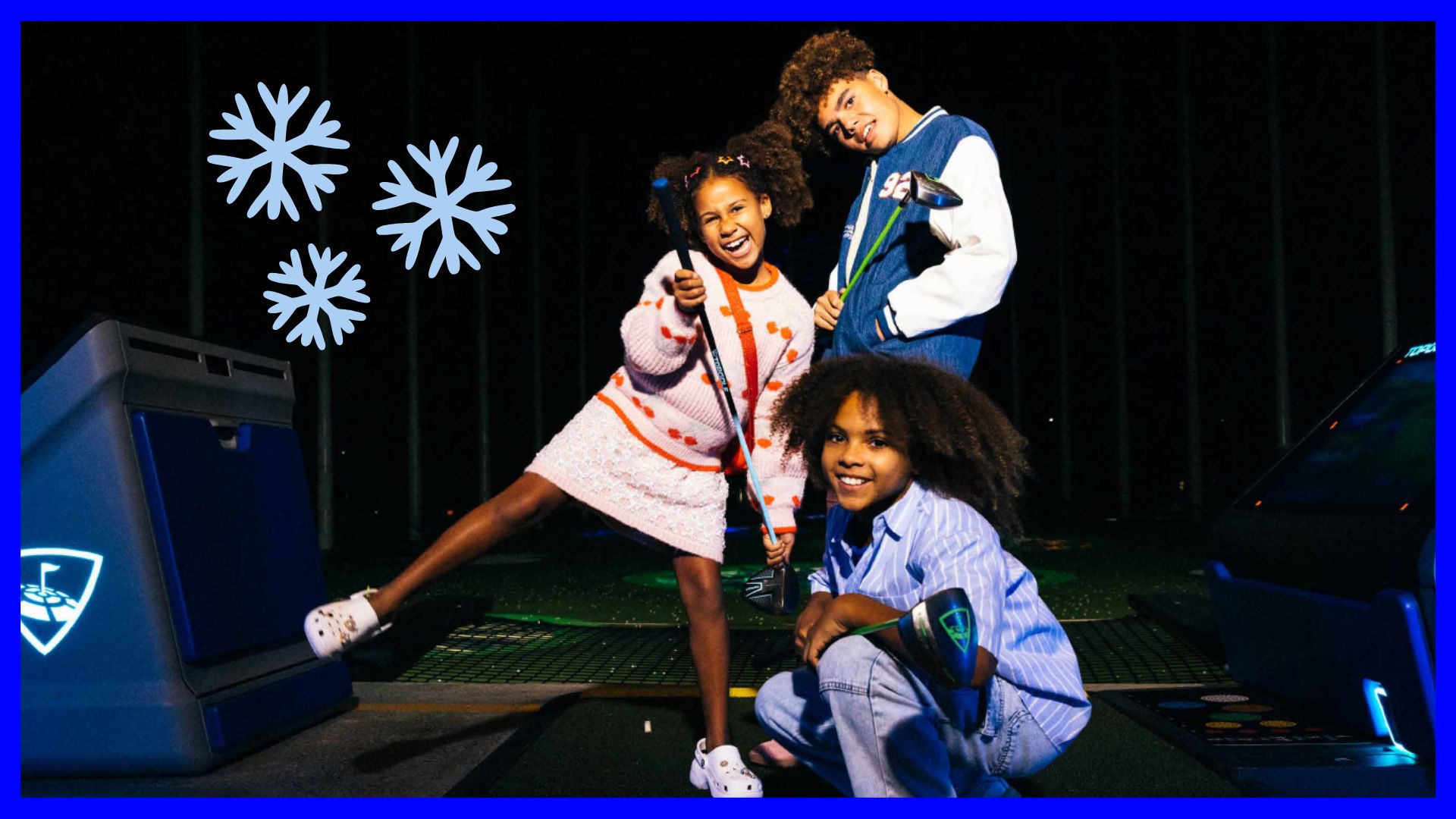 Three smiling children pose with golf clubs at a nighttime driving range. Two are standing, and one is crouched in front. Blue and white snowflake graphics are added to the left. The vibe is playful and fun.