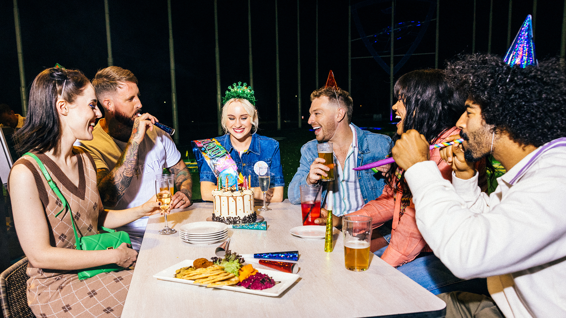 A group of people celebrating a birthday at a party hosted at Topgolf Gold Coast.