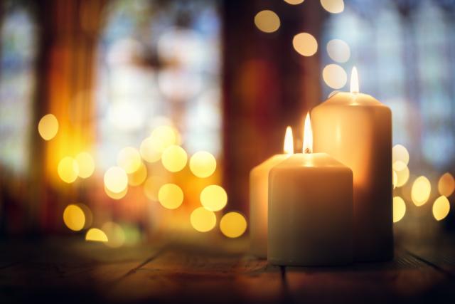 Prière - image de 3 bougies allumées dans une église avec une belle lumière autour 