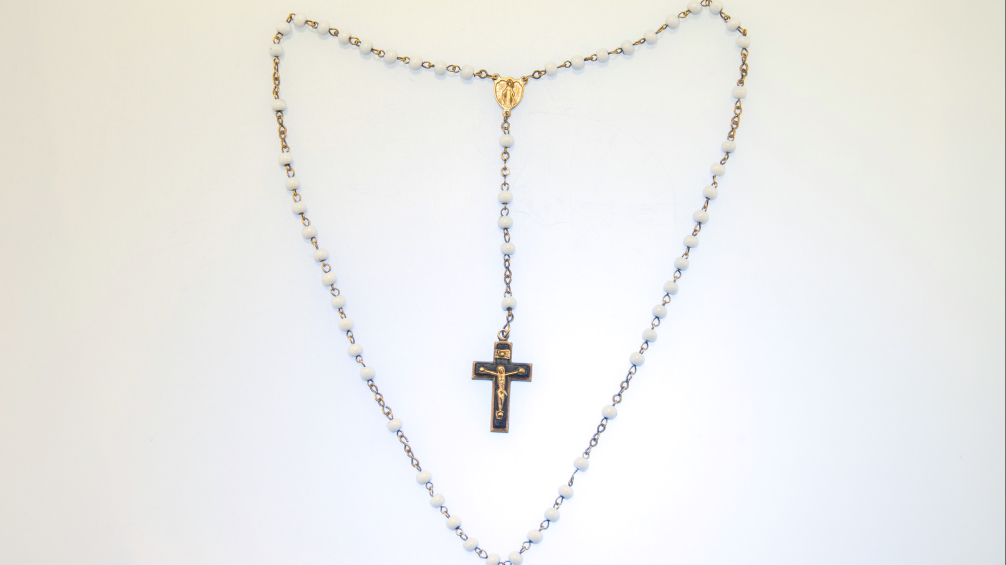 © Getty
ƒ center
Image d'un chapelet catholique en perle avec la croix qui présente Jésus et une médaille de la Vierge Marie 