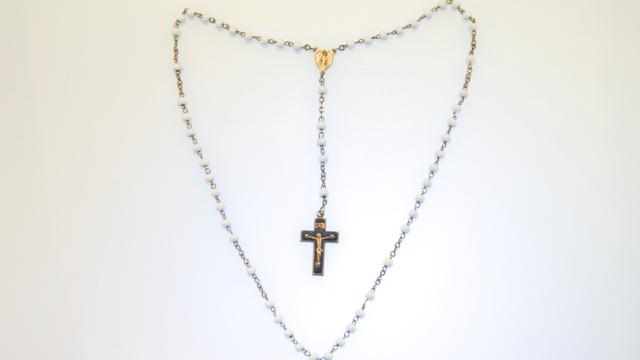 Image d'un chapelet catholique en perle avec la croix qui présente Jésus et une médaille de la Vierge Marie 