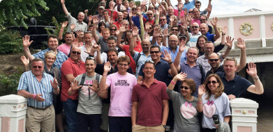 A crowd of PubAid volunteers waving happily