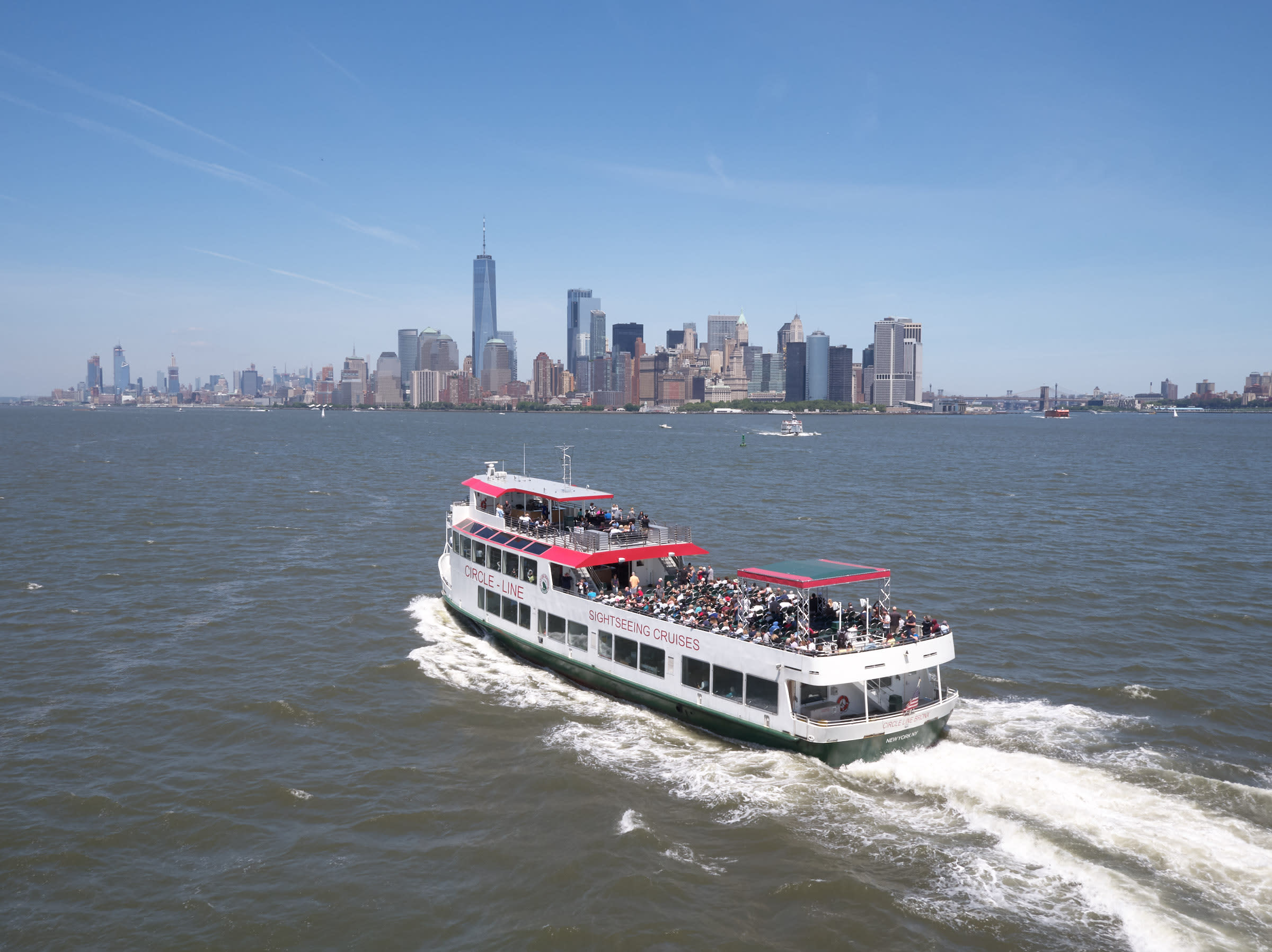 Guests on Best of NYC cruise taking photos of Manhattan skyline.