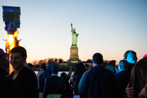 Statue of Liberty peeking above the crowd at Sunset