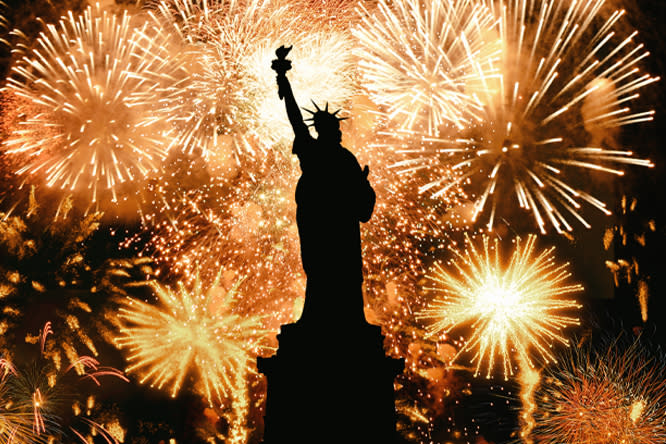 Statue of Liberty with fireworks in the background.