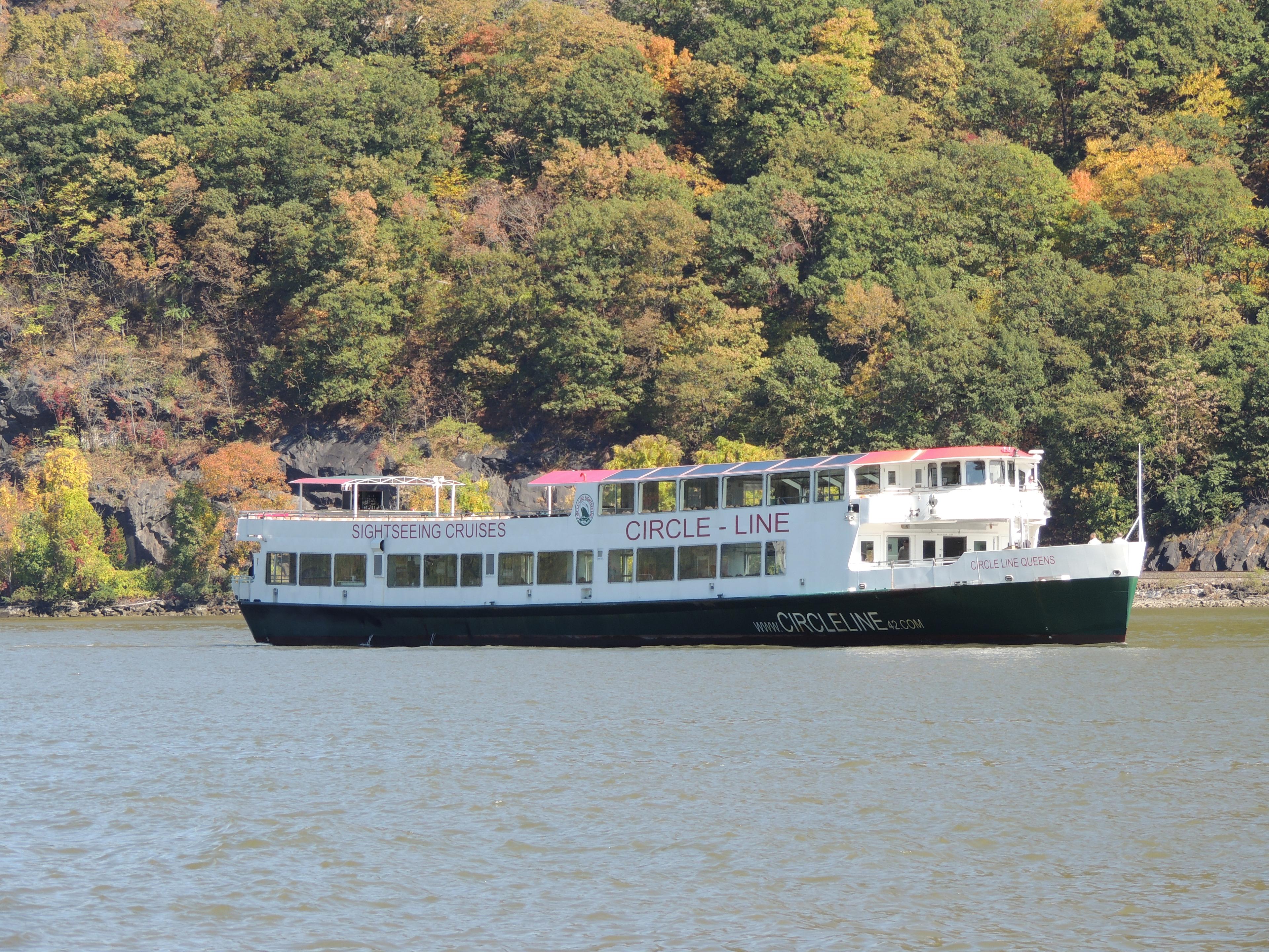 Manhattan Class boat on the Hudson River with fall foliage in the background