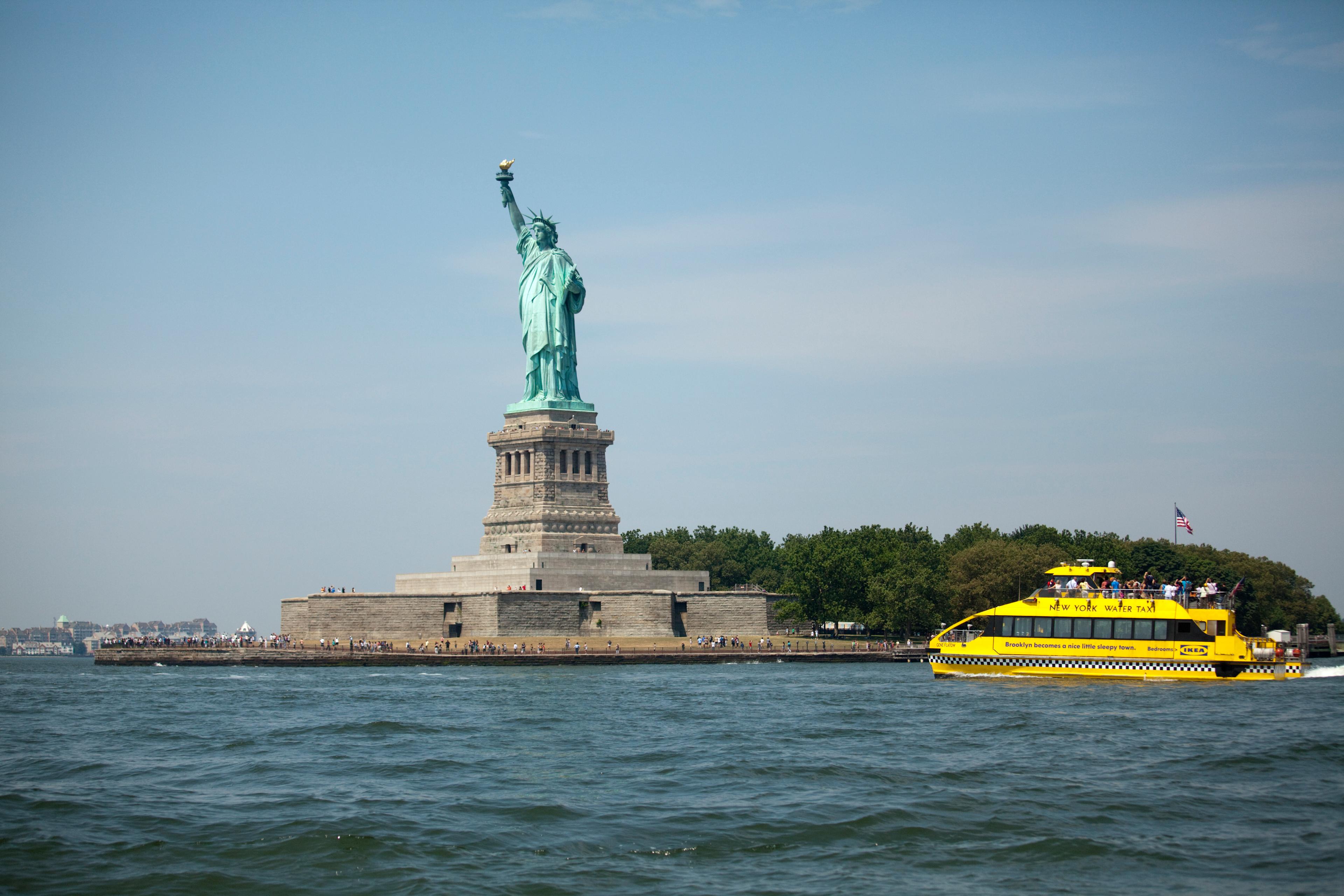 New York Water Taxi sailing in front of Statue of Liberty