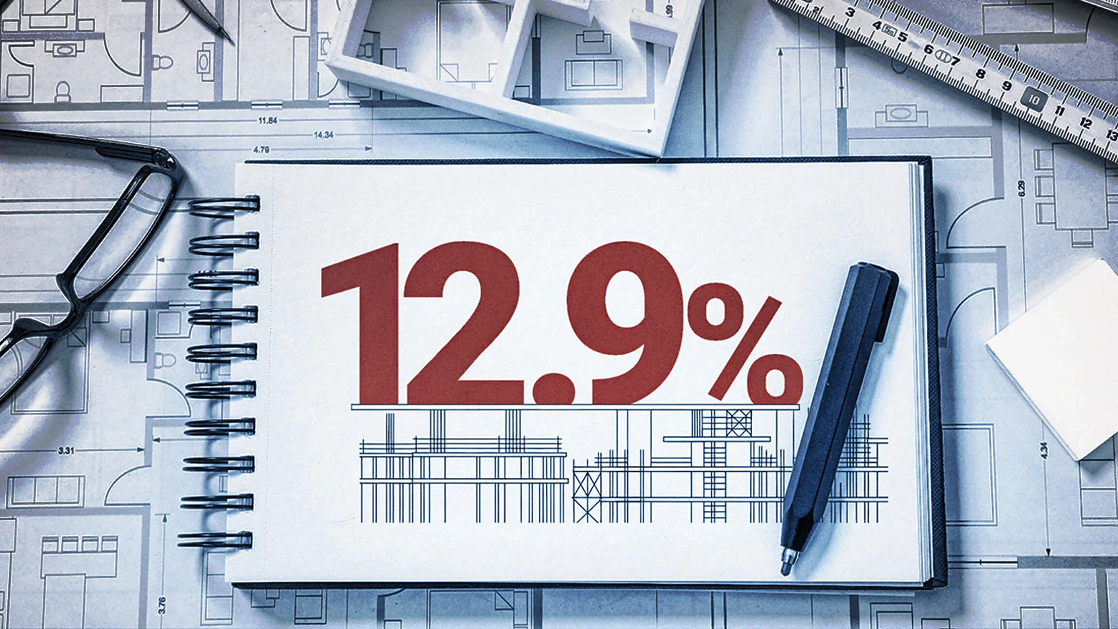 This image presents a construction and architectural planning theme centered around a large spiral-bound notebook placed on top of detailed blueprints and floor plans. Dominating the notebook page is a bold red statistic, “12.9%,” displayed prominently in the center. Below the percentage is a technical line drawing of a building framework, resembling a construction site or structural blueprint. Surrounding the notebook are several design and drafting tools. On the left side, a pair of black-framed eyeglasses rests on the architectural plans. In the upper-right corner, a measuring ruler lies diagonally across the blueprint background. A dark pen is positioned on the right side of the notebook.