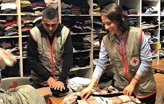 Erika trie les vêtements par sexe, âge et taille avec les autres bénévoles. 