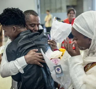 Grâce à la réunification familiale, un couple érythréen retrouve son fils de 17 ans à Roissy.