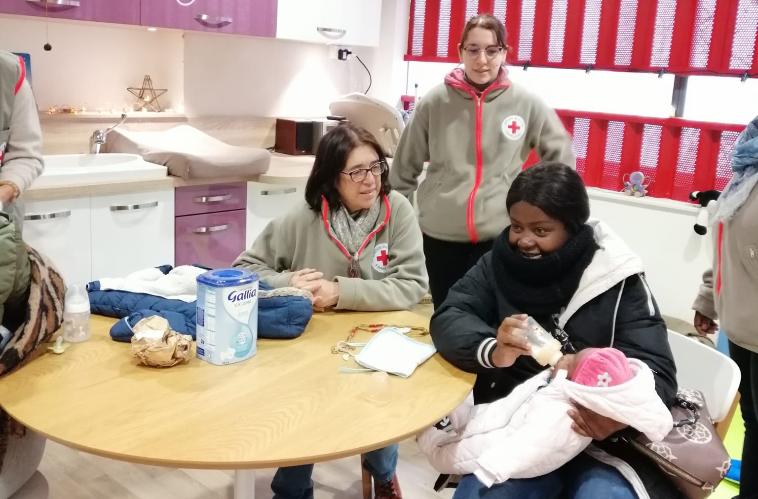Assise au centre de l'image, Christine, responsable de l’Espace bébé-parents d’Angers, entourée de son équipe.