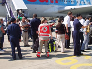 Les volontaires de la Croix-Rouge et les touristes rapatriés montent dans l’avion à l’aéroport de Bangkok.