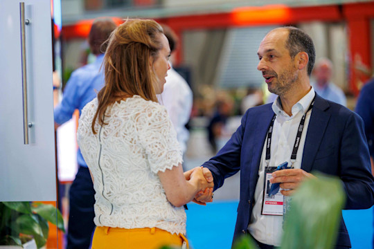 Two people meet and shake hands at Money20/20 Europe