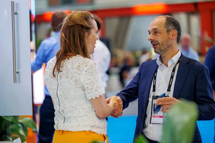 Two people meet and shake hands at Money20/20 Europe
