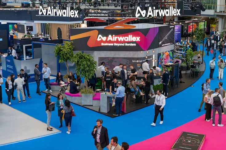 Attendees visit the Airwallex stand and chat in the aisles.