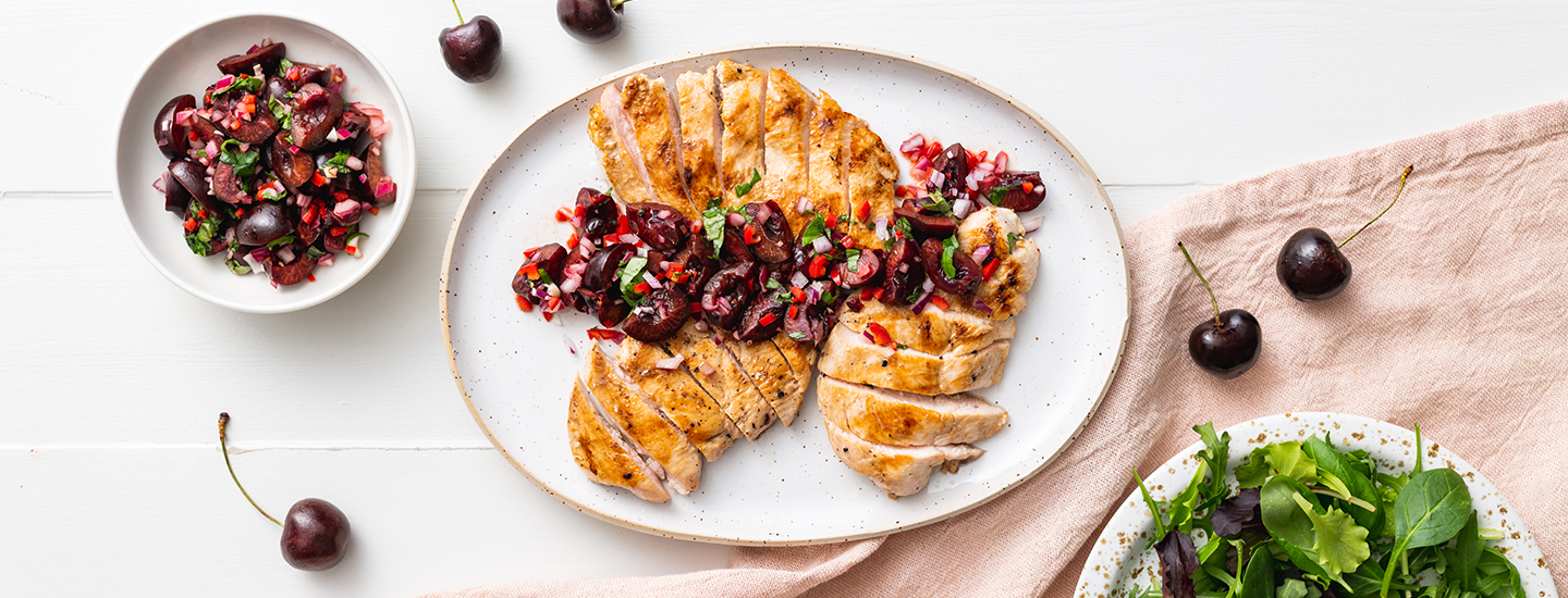 Grillattua kanaa ja kirsikoista tehtyä salsaa valkoisella lautasella.