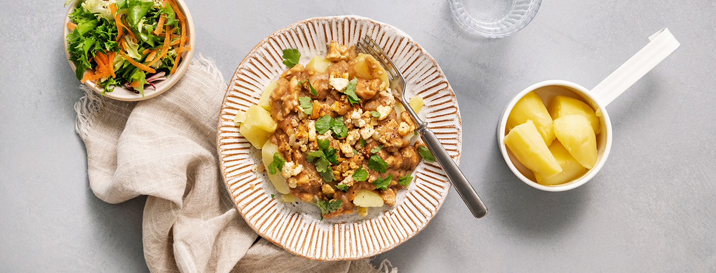 Ruskea tofukastike lautasella keitettyjen perunoiden ja salaatin kanssa. K-Ruoka arkiruokaresepti.