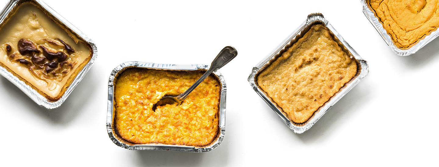 Neljä kaupasta ostettua valmista joululaatikkoa valkoisella taustalla. Joululaatikot on tehty foliovuokiin. Yhdessä joululaatikossa on lusikka. K-Ruoka jouluresepti.