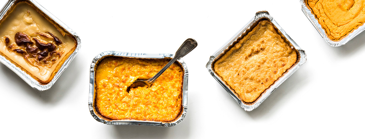 Neljä kaupasta ostettua valmista joululaatikkoa valkoisella taustalla. Joululaatikot on tehty foliovuokiin. Yhdessä joululaatikossa on lusikka. K-Ruoka jouluresepti.