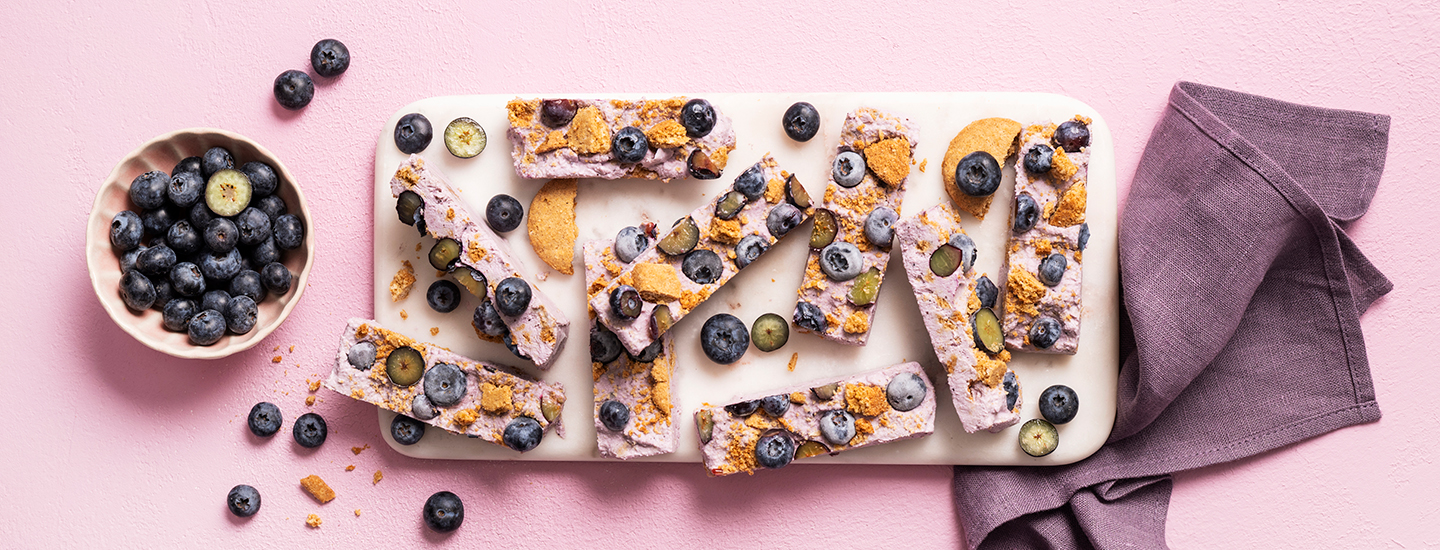 Mustikoista, keksimurusta ja mustikkaraejuustosta tehtyjä jäädytettyjä patukoita. K-Ruoka välipalaresepti.