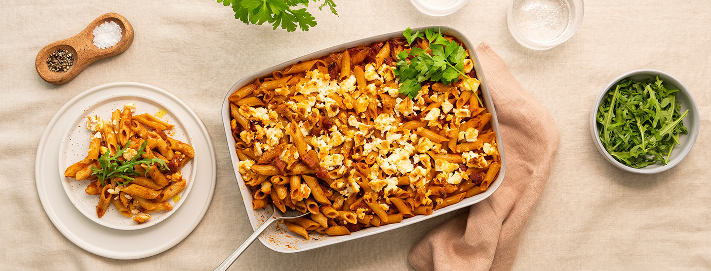 Pennepastaa, fetajuustoa ja chorizo-makkaran siivuja valkoisessa pastavuoassa tomaattisessa kastikkeessa. K-Ruoka arkiruokaresepti.