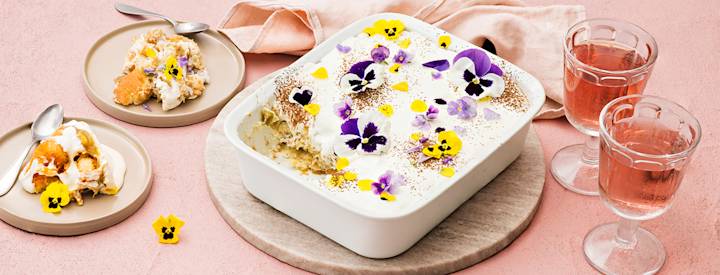 Raparperihillolla täytetty tiramisu suorakulmion muotoisessa vuoassa. Raparperitiramisun päälle on lisätty syötäviä kukkia ja kaakaojauhetta. K-Ruoka jälkiruokaresepti.