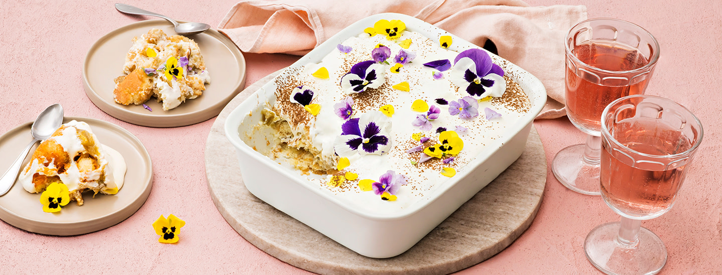 Raparperihillolla täytetty tiramisu suorakulmion muotoisessa vuoassa. Raparperitiramisun päälle on lisätty syötäviä kukkia ja kaakaojauhetta. K-Ruoka jälkiruokaresepti.