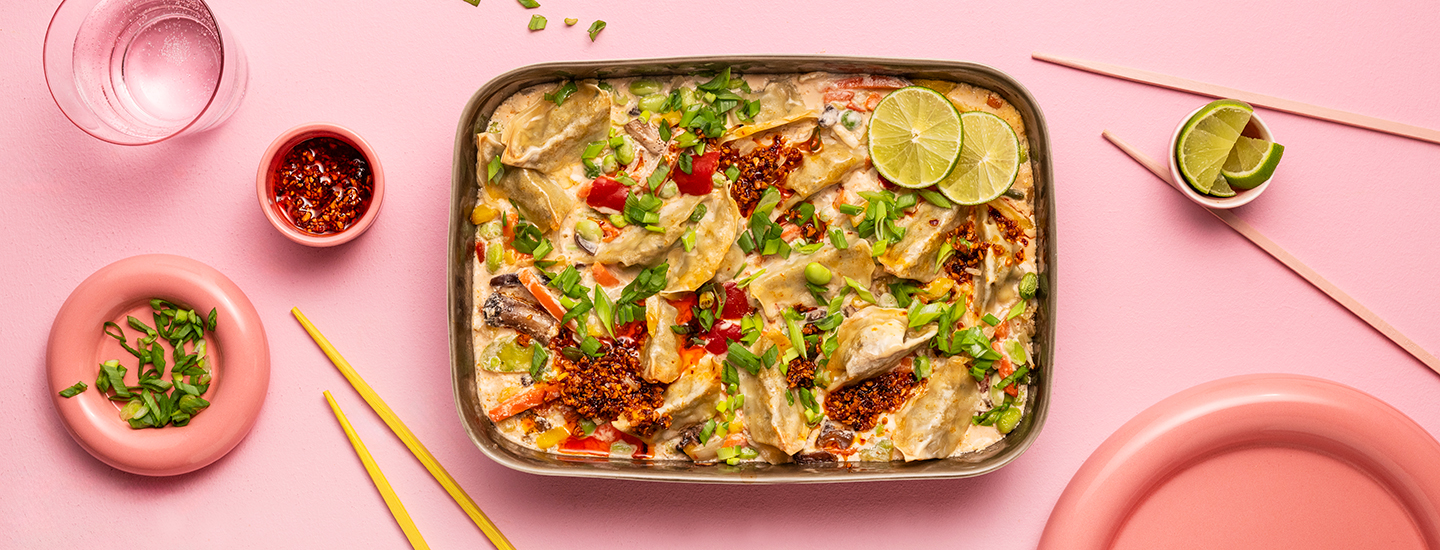 Gyozoja ja wokkivihanneksia kookoskastikkeessa uunivuoassa. Vuokaruoan päälle on lisätty kevätsipulia, rapeaa valkosipulia chilikastikkeessa ja limeä. K-Ruoka arkiruokaresepti.