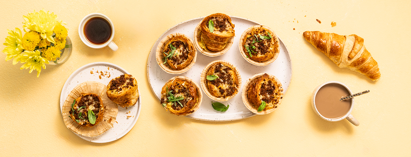 Puolitettuja croissanteja muffinssivuoissa. Puolikkaat croissantit on täytetty juustoisella munakkaalla ja nduja-murulla. K-Ruoka brunssiresepti.