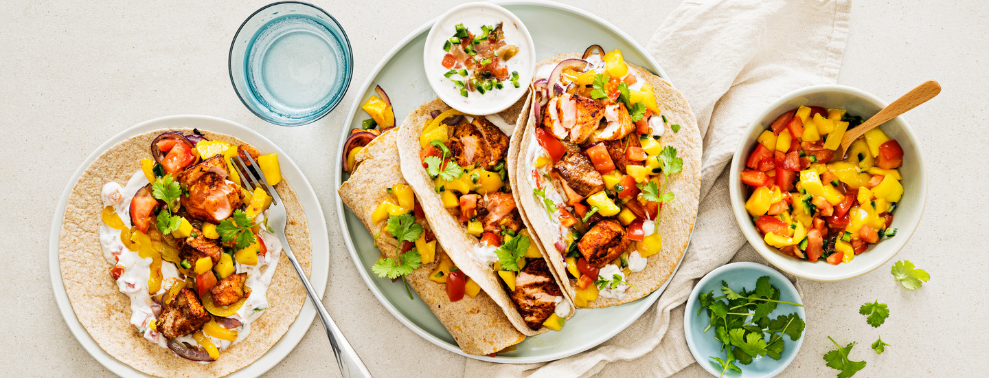 Lohella, mangosalsalla, tuoreilla yrteillä ja ranskankermalla täytettyjä fajitaksia. K-Ruoka texmex-resepti.