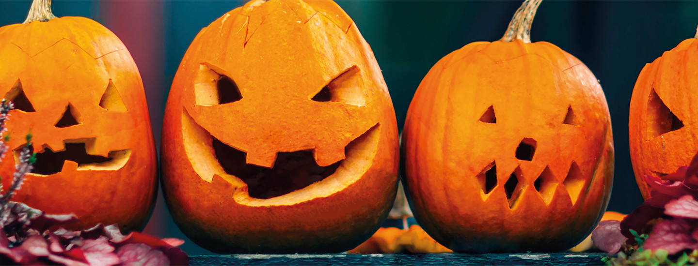 Kuvassa neljä kaiverrettua kurpitsaa.