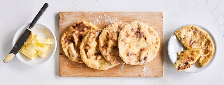 Perunarieskoja puisella leikkuulaudalla. K-Ruoka leipäresepti.