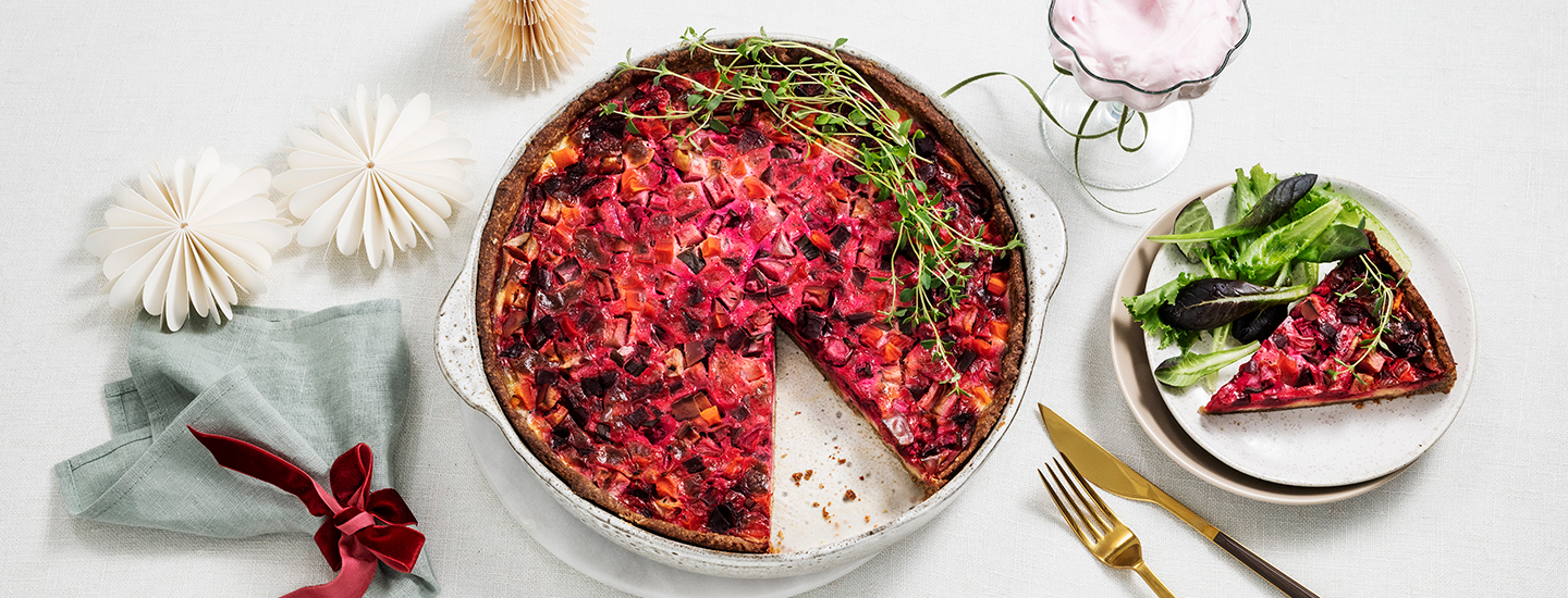 Rosollista tehtyä piirakkaa pyöreässä vuoassa. Piirakan päälle on aseteltu tuoreita yrttejä. K-Ruoka piirakkaresepti.