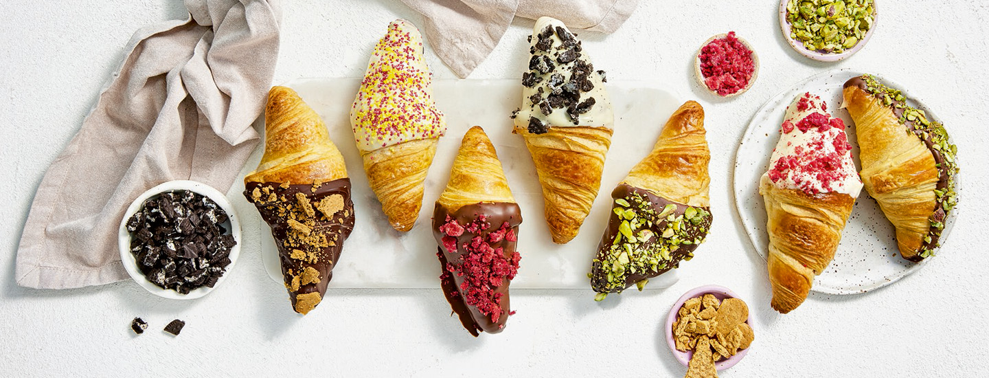 Suklaaseen dipattuja croissantteja vaalealla alustalla. K-Ruoan reseptikuva.