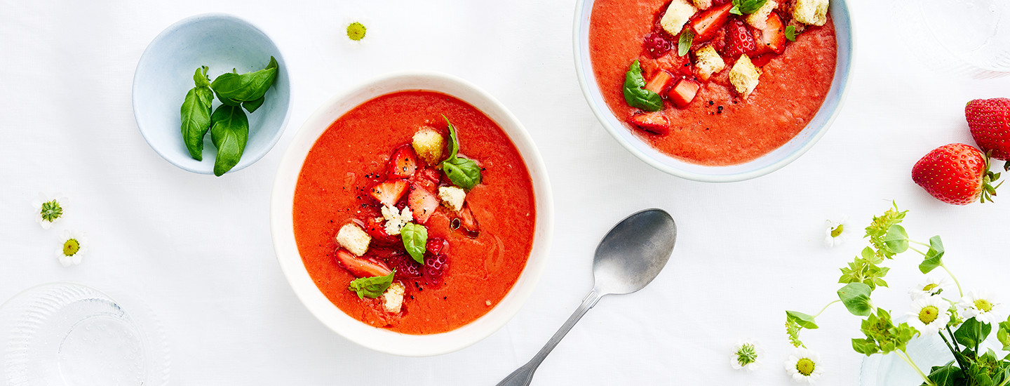 Punainen mansikkagazpachokeitto valkoisessa kulhossa.