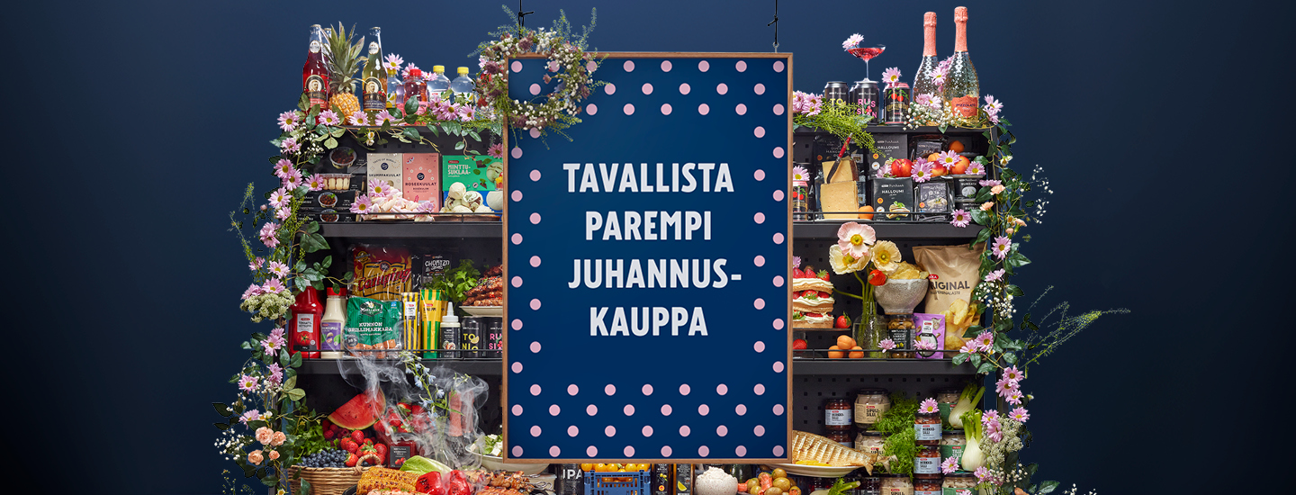Elintarvikkeita ja kukkia täynnä olevien hyllyjen vieressä on laivastonsininen pilkkukyltti, jossa lukee Tavallista Parempi Juhannuskauppa.