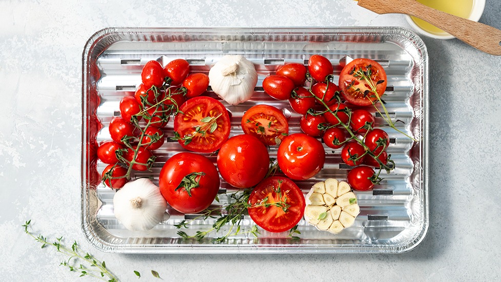 Tomaatteja ja valkosipulia foliovuoassa.