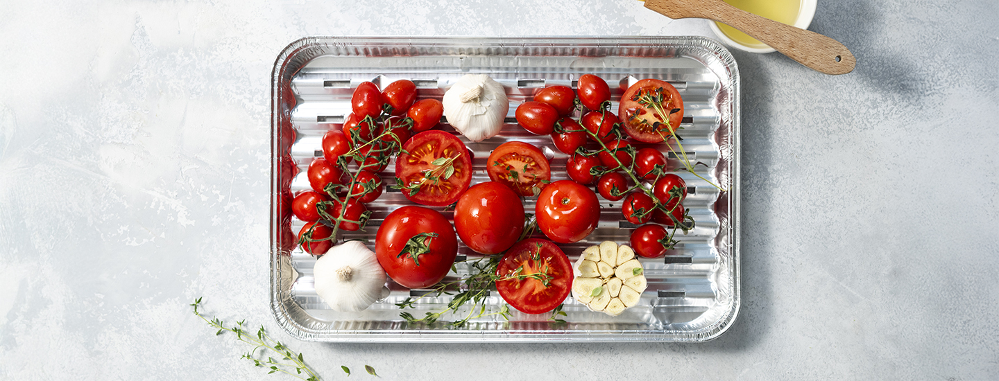 Tomaatteja ja valkosipulia foliovuoassa.