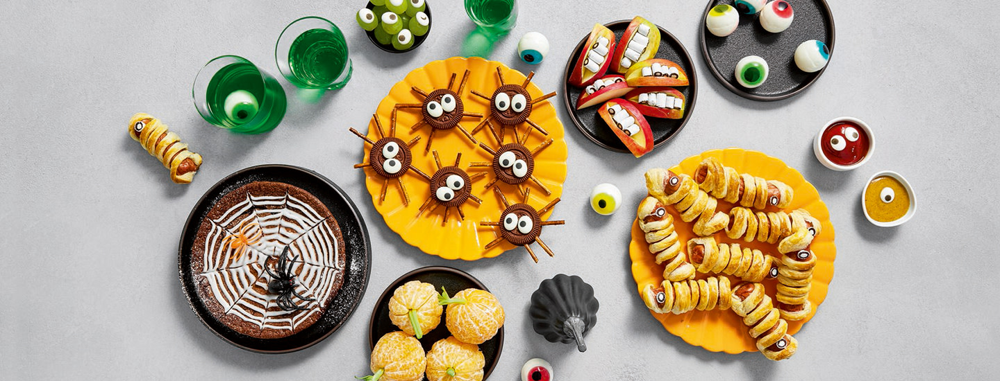 Halloween-koristeltuja pikkusyötäviä harmaalla alustalla. K-Ruoan kuvituskuva