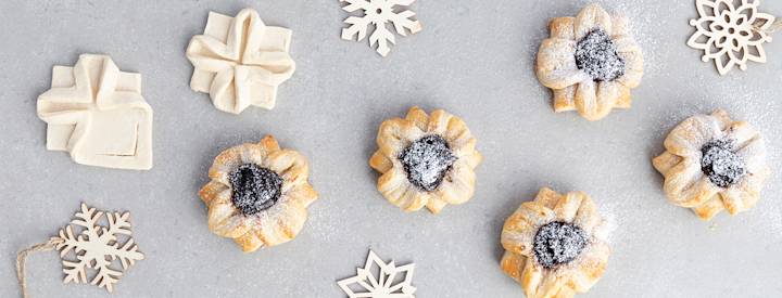 Kukan muotoon taiteltuja joulutorttuja. Joulutorttujen täytteenä on luumuhilloa ja niiden päälle on ripoteltu tomusokeria. K-Ruoka jouluresepti.