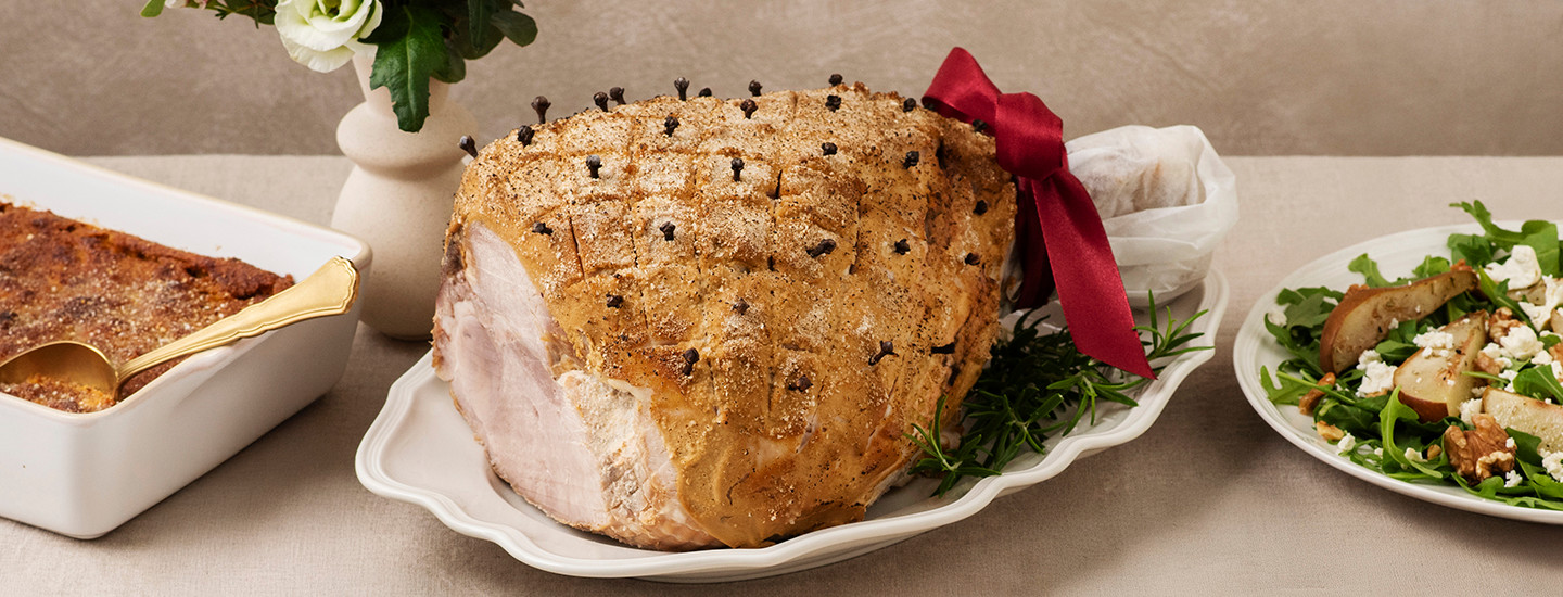 Kokonainen kuorrutettu joulukinkku valkoisella tarjottimella. Kinkku on kuorrutettu sinappihunnulla. K-Ruoka jouluresepti.