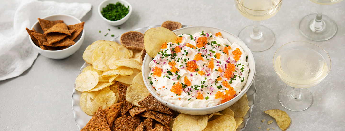 Mätidippiä valkoisessa kulhossa. Kulho on asetettu isomman kulhon päälle, jossa on myös erilaisia sipsejä päällä. K-Ruoka resepti.