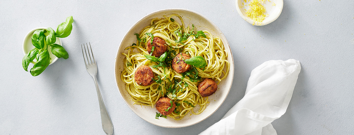 Spagettia ja kalapyöryköitä lautasella. Ruoan päälle on ripoteltu tuoreita yrttejä ja sitruunankuorta. K-Ruoka arkiruokaresepti.