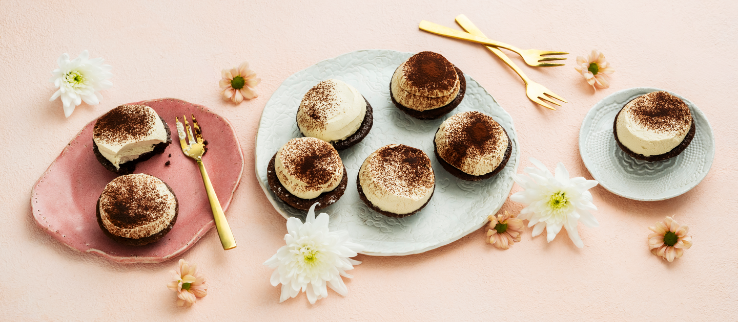  Mutakakuista ja cappuccinolla maustetusta mascarpone-kermavaahdosta tehtyjä leivoksia lautasella. 